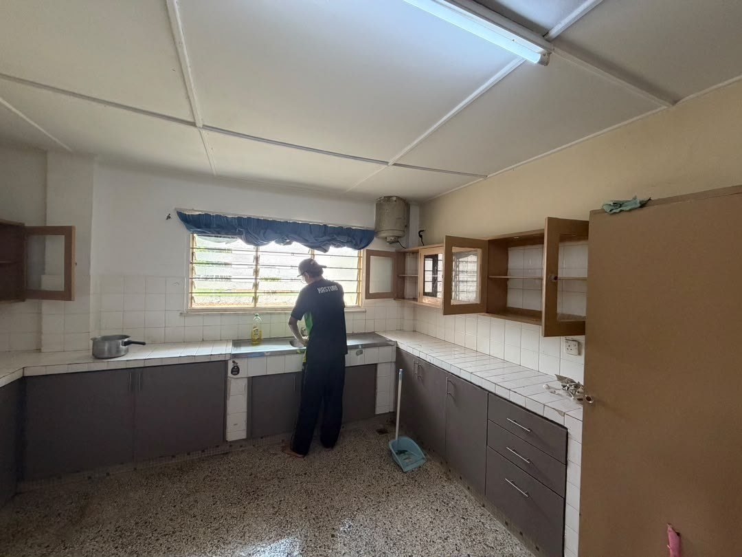Residents tidying a shared kitchen, seen from behind