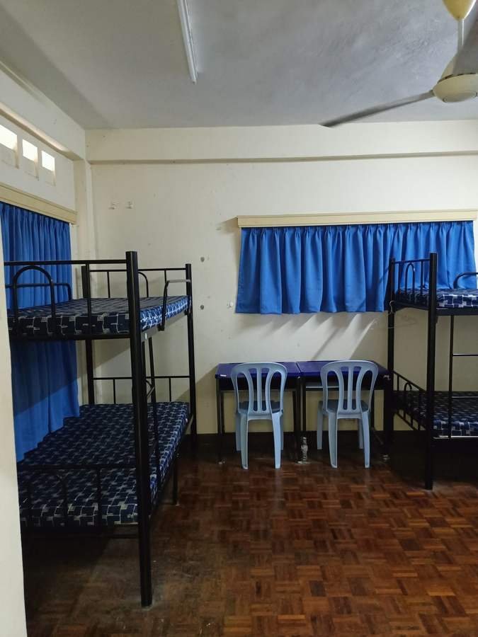 A shared bedroom with bunk beds and blue curtains